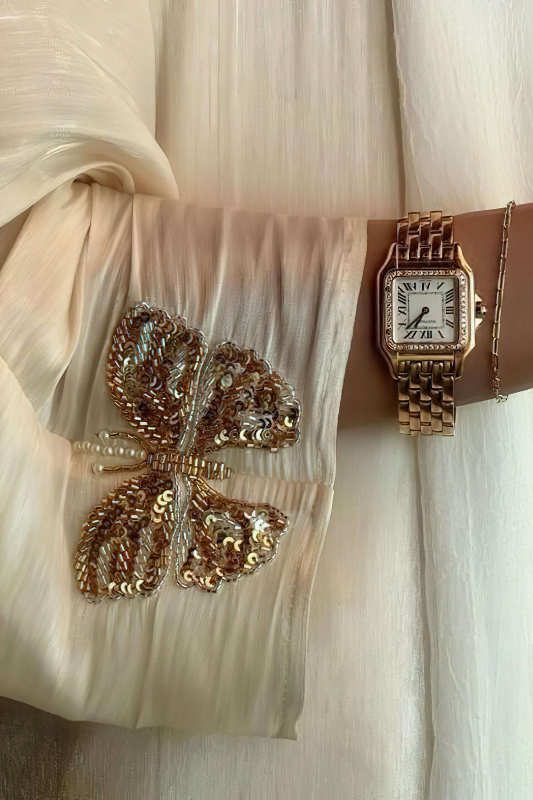 Founder in silk dress with Cartier watch representing high-ticket authority and premium business strategy.